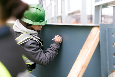 Staff, construction teams and company leadership signed the beam before it was put into place, signifying the pride, dedication and achievements of the team in reaching this important project milestone.