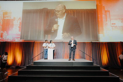 Dan Clement, CEO and President of United Way Centraide, shares the impactful work of their organization with Marlon Antonio and Elsa Antonio, Lead Mentor, Founder, and CEO of Greatway Financial Inc., during the ceremonial cheque presentation at the Convention of Champions 2024. This memorable moment took place on the third day of the event at The International Centre in Mississauga, Ontario, on July 28, 2024. (CNW Group/Greatway Financial Inc)